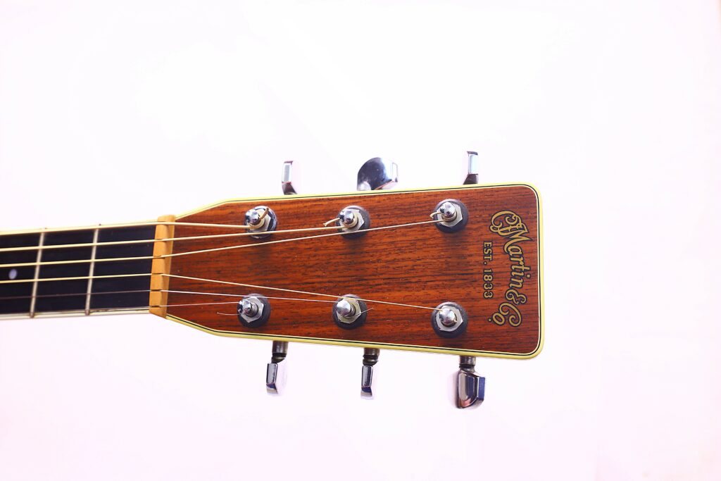 Close-Up Of The Martin M-38 1979 Acoustic Guitar Headstock, Featuring Tuning Pegs, Strings, And The Martin &Amp; Co. Est. 1833 Logo, Set Against A Plain White Background.