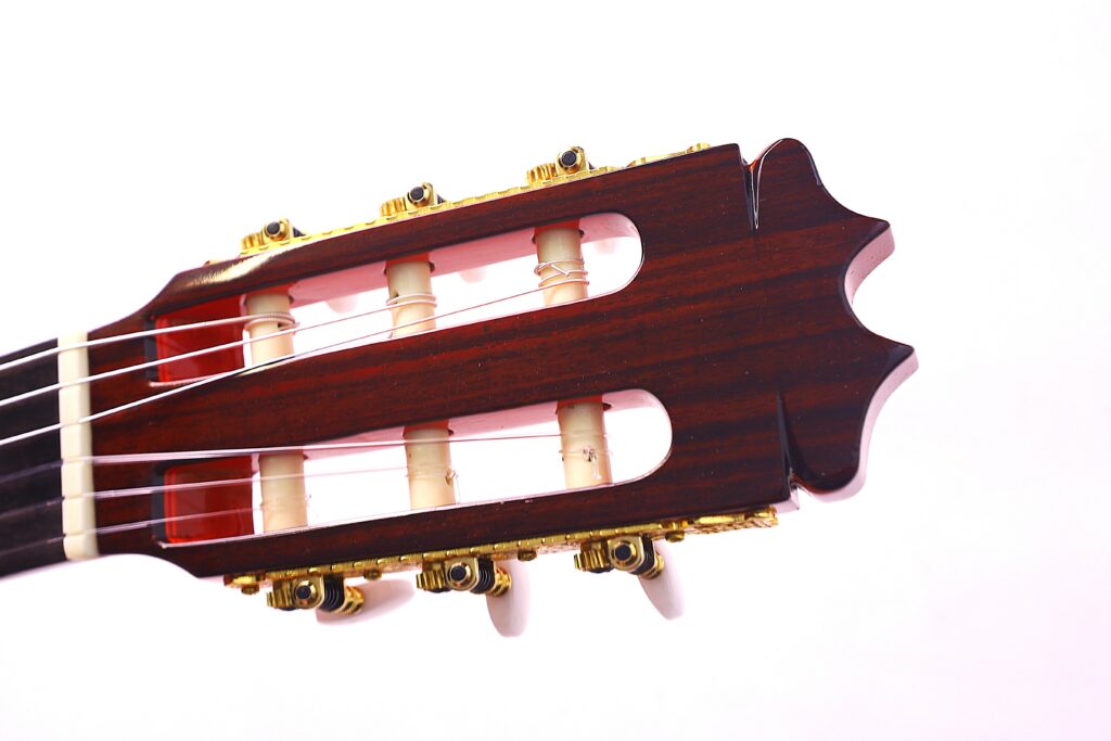 Close-Up Of The Headstock Of The Hermanos Conde 1999 Paco De Lucia Special Flamenco Guitar, Showing Six Tuning Pegs, Gold Hardware, And Nylon Strings On A White Background.