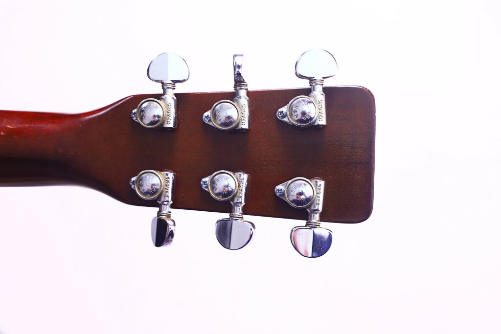 Close-Up Of The Back Of A Martin D-18 1967 Acoustic Guitar Headstock With Six Shiny Silver Tuning Pegs, Set Against A Plain White Background.