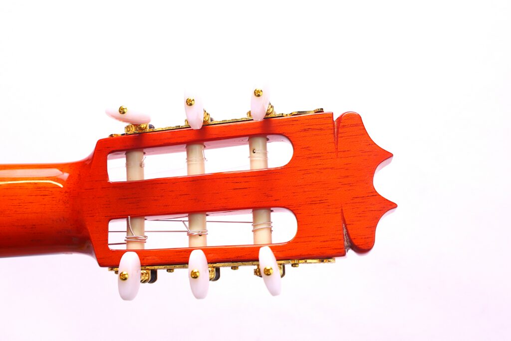 Close-Up Of The Hermanos Conde 1999 Paco De Lucia Special Flamenco Guitar Headstock With Wooden Finish, White Tuning Pegs, And Gold Hardware Against A Plain White Background.