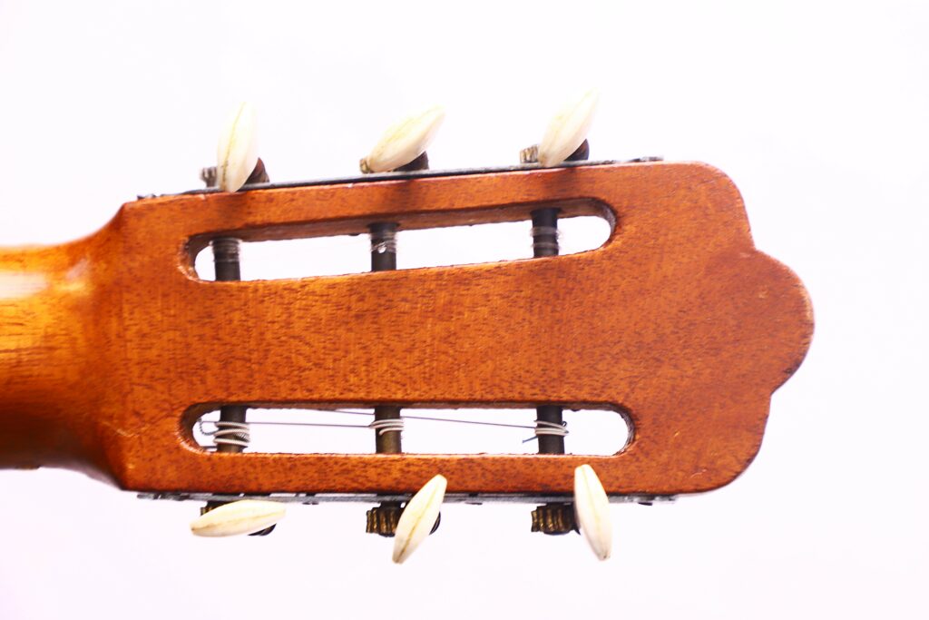 Close-Up Of The Headstock Of An Augustin Gaspar Cebrian 1935 Classical Guitar, Featuring Wooden Tuning Pegs And Metal Strings Against A White Background.