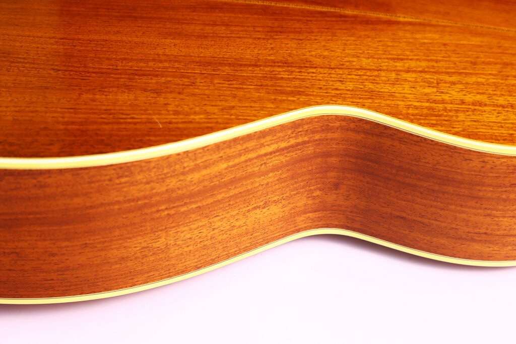Close-Up Of The Side Of A Martin M-38 1979 Acoustic Guitar, Highlighting Its Smooth, Polished Wood Grain And Light-Colored Trim Against A Plain White Background.