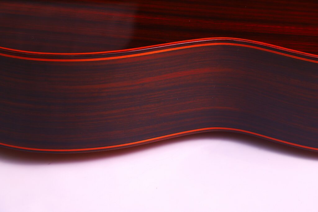 Close-Up Of A Hermanos Conde 1999 Paco De Lucia Special Flamenco Guitar Side, Featuring Dark Wood Grain With Reddish-Brown Stripes And Smooth, Curved Edges Against A White Background.