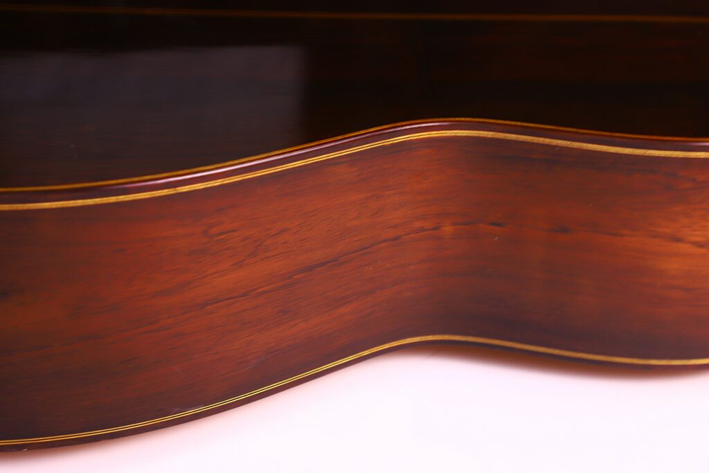 Close-Up Of The Polished Wooden Side Of A José Ruiz Pedregosa 2020 Classical Guitar, Featuring Rich Brown Wood Grain And Thin Yellowish Inlay Lines Along The Edges.