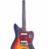 Die Fender Jaguar 1963 E-Gitarre verfügt über ein Sunburst-Finish, abgenutzte Kanten, zwei Tonabnehmer, ein Schildpatt-Schlagbrett und einen Ahorn-Hals mit dem Fender-Logo auf der Kopfplatte. Die Fender Jaguar 1963 E-Gitarre verfügt über ein Sunburst-Finish, abgenutzte Kanten, zwei Tonabnehmer, ein Schildpatt-Schlagbrett und einen Ahorn-Hals mit dem Fender-Logo auf der Kopfplatte.