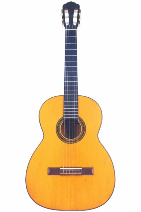 The Adolf Meinel 1984 Classical Guitar features a light wood body, dark fretboard, and six strings, shown against a white background.