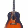 Eine Gibson Southern Jumbo 1955 Akustik Gitarre mit Sunburst-Finish, die sichtbare Gebrauchsspuren und Kratzer am Schallloch und am Korpus aufweist, ist vor einem schlichten weißen Hintergrund fotografiert. Eine Gibson Southern Jumbo 1955 Akustik Gitarre mit Sunburst-Finish, die sichtbare Gebrauchsspuren und Kratzer am Schallloch und am Korpus aufweist, ist vor einem schlichten weißen Hintergrund fotografiert.