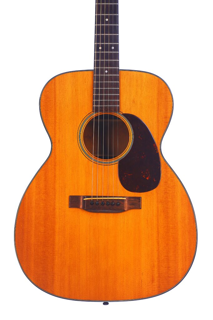 The Martin 000-18 1950 Acoustic Guitar Features A Light Brown Wooden Body, Dark Pickguard, And Six Strings, Shown Here Against A White Background.