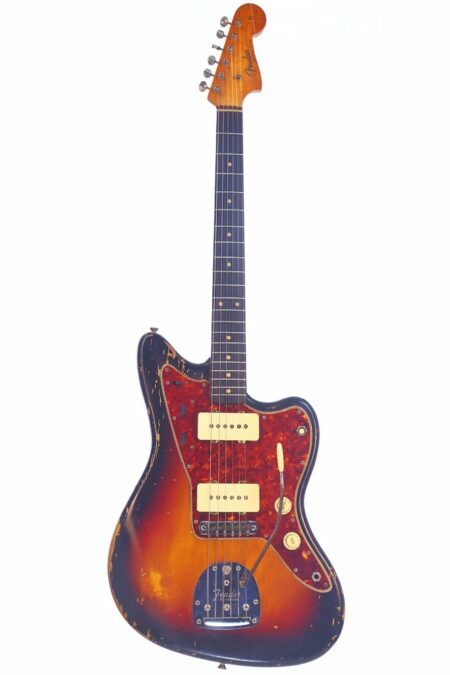 The Fender Jazzmaster 1962 Electric Guitar features a sunburst finish, worn edges, cream pickups, a red tortoiseshell pickguard, and a classic offset body, shown here against a white background.