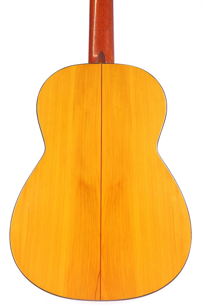 The Image Shows The Back Of A Conde Hermanos 1971 Flamenco Guitar With A Smooth, Light Wood Finish And Visible Center Seam, Photographed Against A White Background.