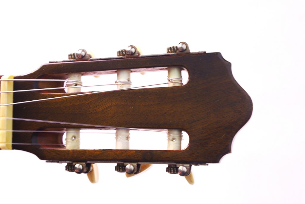 Close-Up Of The Headstock Of A Conde Hermanos 1971 Flamenco Guitar, Highlighting Tuning Pegs, Strings, And Wooden Finish Against A White Background.