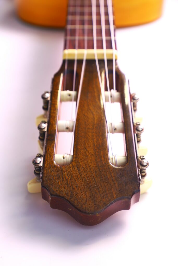 Close-Up View Of The Tuning Head And Strings Of A Conde Hermanos 1971 Flamenco Guitar, Highlighting Its Wooden Finish And Tuning Pegs Against A White Background.