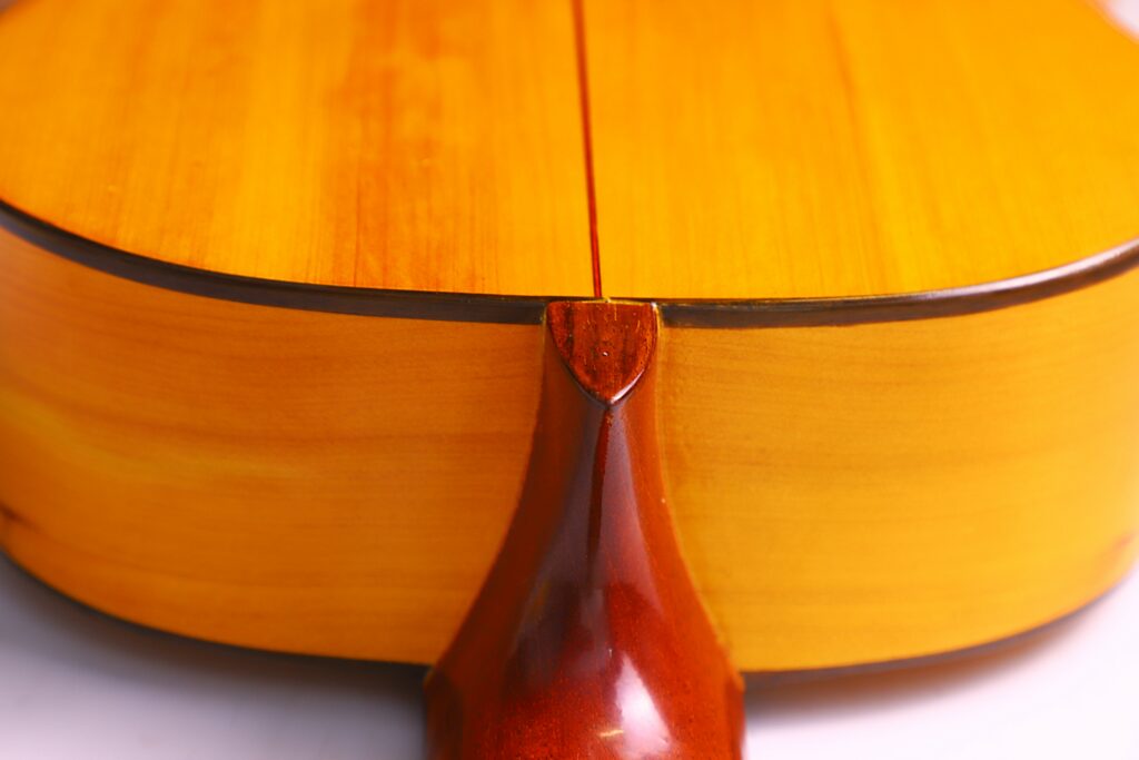 Close-Up Of The Back Of A Conde Hermanos 1971 Flamenco Guitar, Highlighting The Glossy Wood Finish, Visible Center Seam, And The Junction Where The Neck Meets The Body.