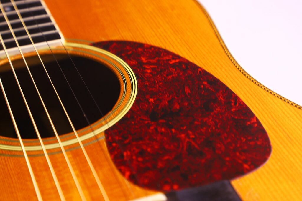 Close-Up Of A Martin Hd-35 1979 Acoustic Guitar, Highlighting Its Wooden Body, Strings, Sound Hole With Decorative Trim, And A Reddish-Brown Tortoiseshell Pickguard.