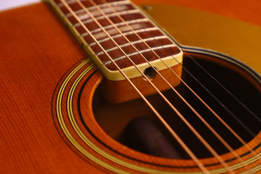 Close-Up Of The Fender Wildwood 1967 Acoustic Guitar, Highlighting Its Strings, Fretboard, And Soundhole With Detailed Wood Grain And Distinctive Circular Decorations.