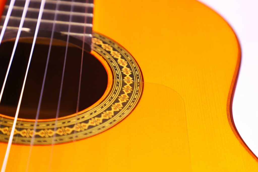Close-Up Of The Hermanos Conde 1986 Paco De Lucia Flamenco Guitar, Highlighting Its Strings, Sound Hole, Ornate Rosette, And Warm Yellow Wood Finish On The Classic Wooden Body.