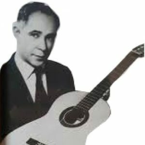 A black and white photo of a man in a suit holding a classical guitar, looking towards the camera against a plain white background—a tribute to Marcelo Barberos iconic guitar craftsmanship.