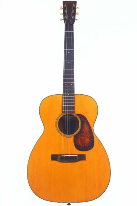 A Martin 00-18 1944 Acoustic Guitar with a natural wood finish, dark pickguard, six strings, and dot inlays is shown against a plain white background.
