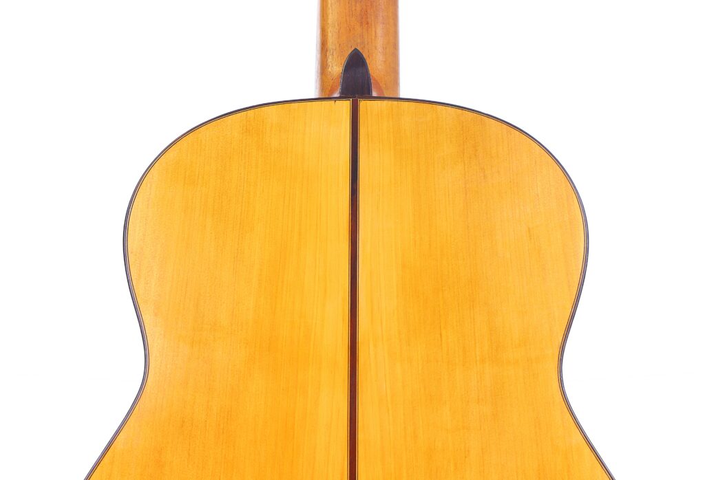 Close-Up Of The Gerundino Fernandez 1990 Flamenco Guitar’s Back, Featuring Smooth Light Brown Wood With A Central Dark Line And Rounded Edges Bordered By A Fine Dark Trim.