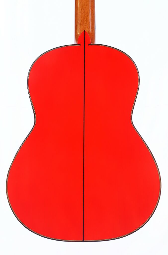 The Pedro Fernández Luque 2021 Blanca Flamenco Guitar Features A Bright Red Back With A Dark Outline, Displayed On A Plain White Background. Its Neck Is Finished In A Natural Wood Color.