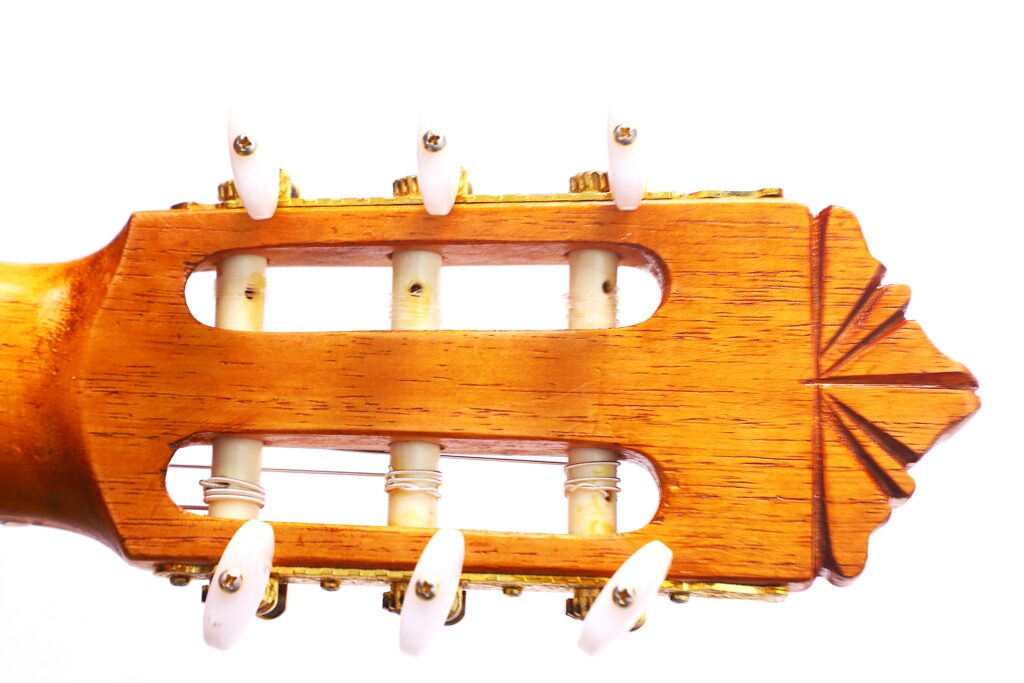 Close-Up Of The Gerundino Fernandez 1990 Flamenco Guitar Headstock, Featuring Tuning Pegs With White Knobs And Wooden Accents, Set Against A White Background.