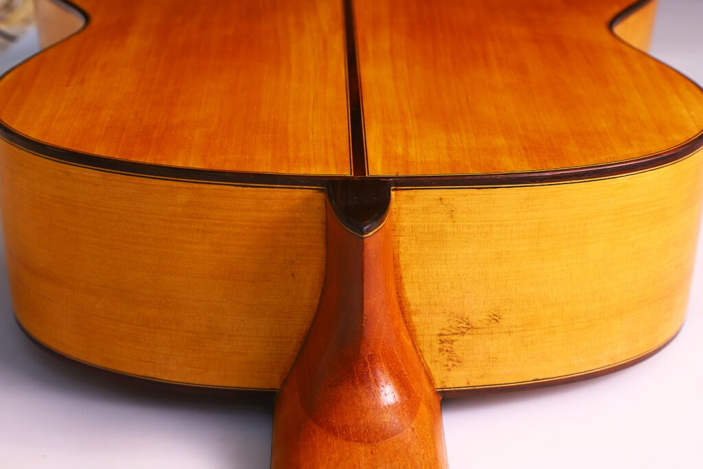 Close-Up Of The Neck Joint On A Gerundino Fernandez 1990 Flamenco Guitar, Highlighting The Smooth Light-Brown Varnished Wood And Fine Craftsmanship.