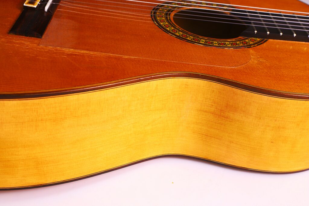 Close-Up Of The Gerundino Fernandez 1990 Flamenco Guitar, Highlighting Its Wooden Body, Rosette, Strings, Fretboard, And The Instrument’s Smooth Finish And Craftsmanship.