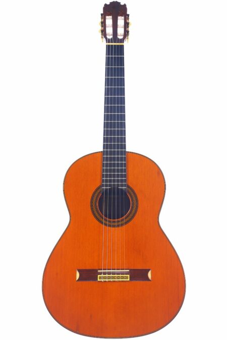 The Manuel Contreras N-2 1987 Classical Guitar features a wooden body, dark fingerboard, six strings, and a decorative rosette, shown against a white background.