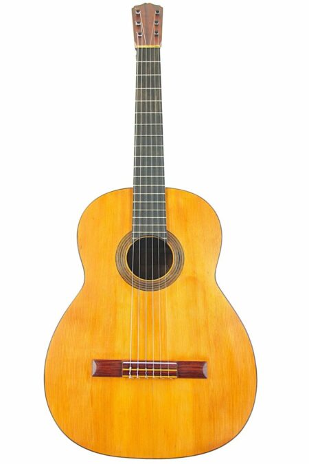 The Enrique Sanfeliu 1920 Flamenco Guitar features a wooden body, six strings, a dark fretboard, and a simple rosette around the sound hole, shown against a white background.