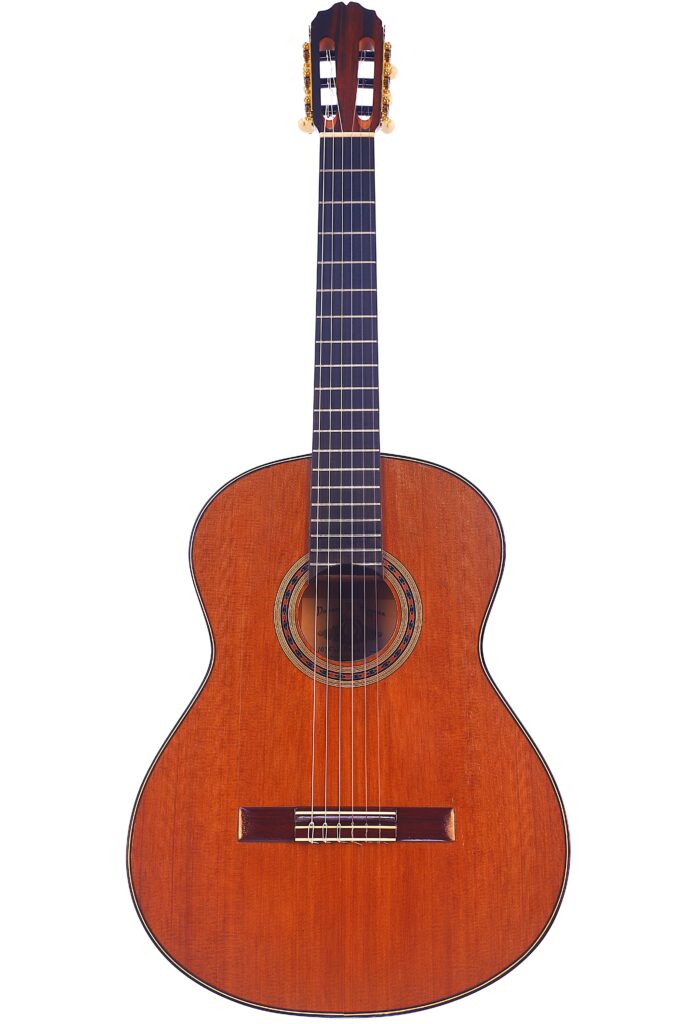 The Manuel Reyes model 2021 by Hippner Flamenco guitar, a classic acoustic guitar with a wooden body, dark fingerboard and six nylon strings, is elegantly photographed against a white background. The Manuel Reyes Model 2021 by Hippner Flamenco Guitar, a classic acoustic guitar with a wooden body, dark fingerboard and six nylon strings, is elegantly photographed against a white background.