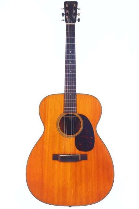 A full view of the Martin 000-18 1958 Acoustic Guitar with a natural wood finish, dark fretboard, six tuning pegs, and a dark pickguard against a white background.