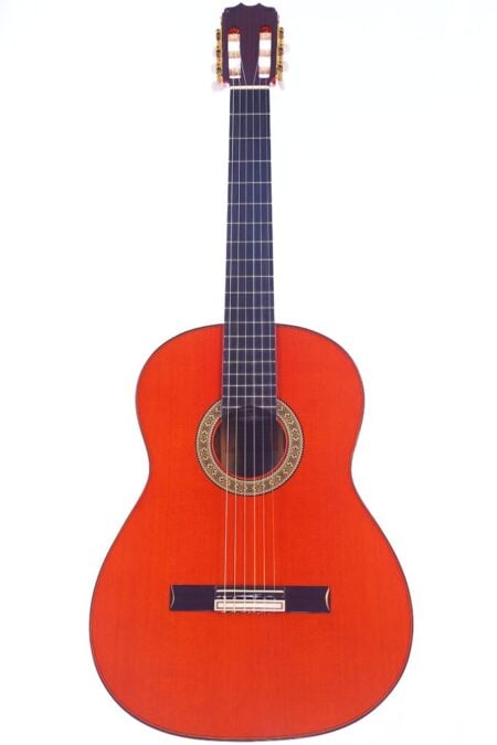 Die Hermanos Conde 1991 Paco de Lucia Special Flamenco Gitarre ist eine klassische Akustikgitarre mit einem rötlich-braunen Holzkörper, sechs Saiten, einem dunklen Griffbrett und dekorativen Schalllochdetails, die vor einem weißen Hintergrund gezeigt wird. Die Hermanos Conde 1991 Paco de Lucia Special Flamenco Gitarre ist eine klassische Akustikgitarre mit einem rötlich-braunen Holzkörper, sechs Saiten, einem dunklen Griffbrett und dekorativen Schalllochdetails, die vor einem weißen Hintergrund gezeigt wird.