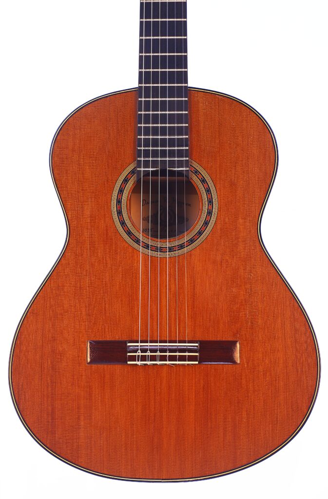 Die Manuel Reyes Model 2021 Von Hippner Flamenco Gitarre Ist Eine Klassische Akustikgitarre Mit Holzkörper, Sechs Saiten, Dekorativem Runden Schallloch Und Dunklem Griffbrett, Dargestellt Vor Einem Weißen Hintergrund.