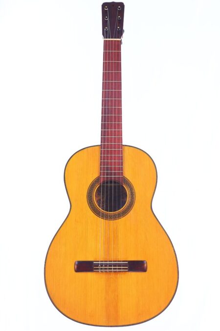 The Jose Ramirez 1950 Flamenco Guitar features a light wooden body, dark neck, and six strings, displayed against a plain white background.