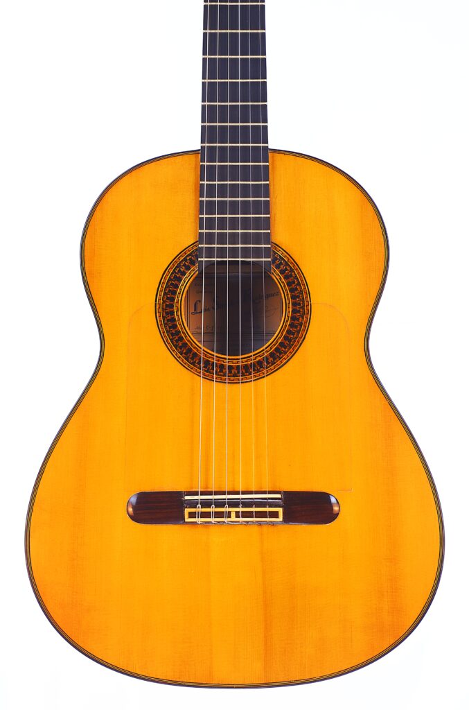 Die Luis Sanchez 2011 Negra Flamenco Gitarre Zeichnet Sich Durch Einen Hellen Holzkörper, Einen Dunklen Holzsteg, Sechs Saiten Und Eine Kunstvolle Rosette Um Das Schallloch Aus, Fotografiert Vor Einem Weißen Hintergrund.