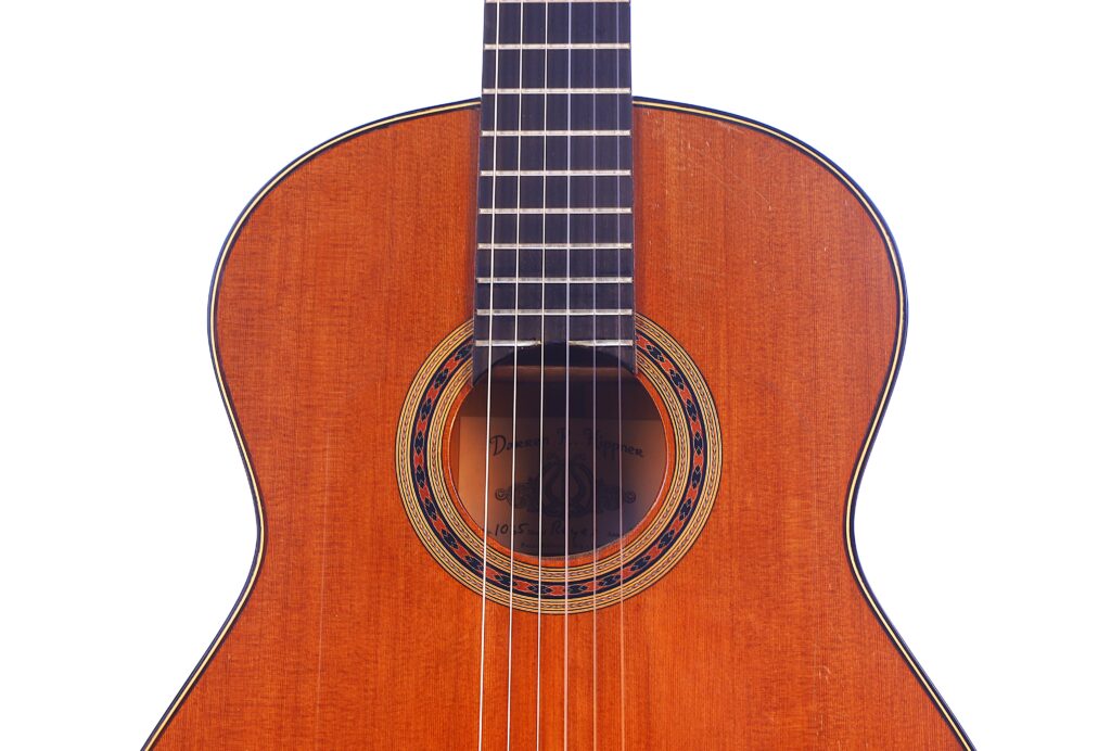 Eine Nahaufnahme Der Manuel Reyes Model 2021 Von Hippner Flamenco Gitarre Hebt Ihre Holzoberfläche, Das Detaillierte Schallloch Und Die Nylonsaiten Vor Einem Weißen Hintergrund Hervor.