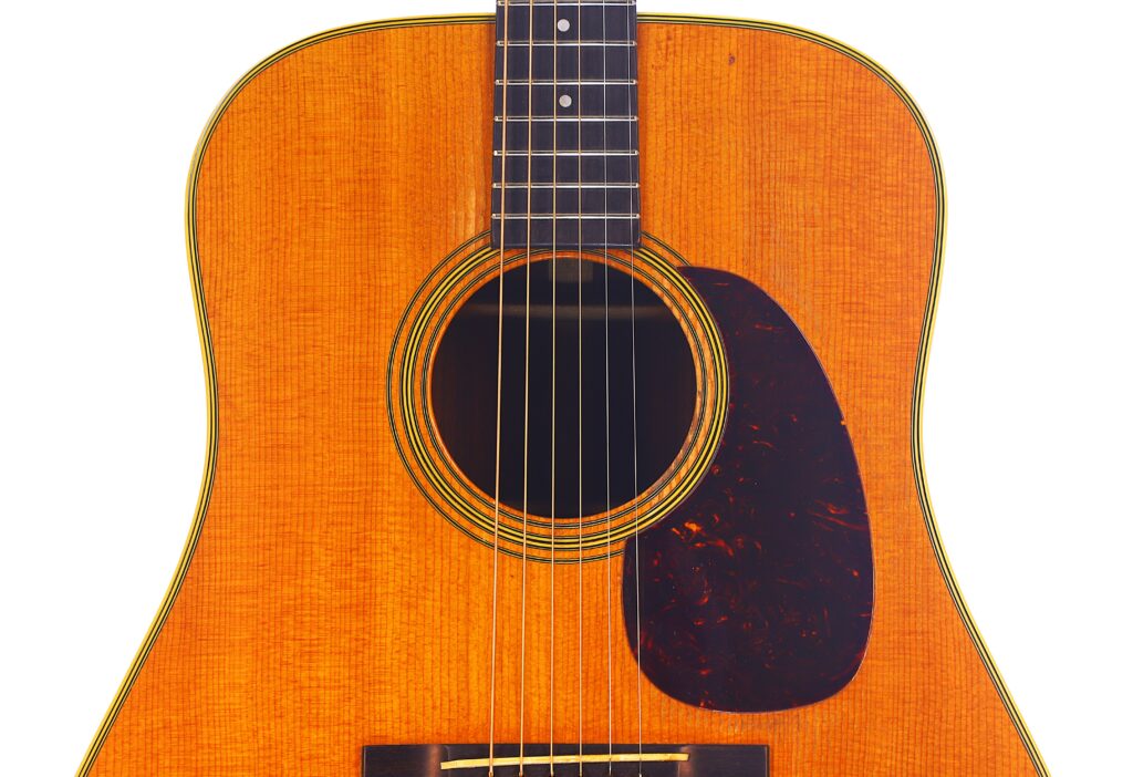 Nahaufnahme Einer Martin D-28 1950 Akustik Gitarre, Die Ihren Holzkörper, Das Schallloch, Die Saiten, Das Griffbrett Und Das Dunkelbraune Schlagbrett Vor Einem Weißen Hintergrund Hervorhebt.