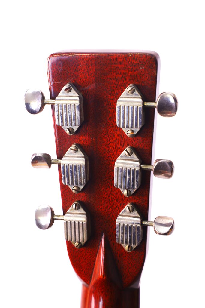 Nahaufnahme Der Rückseite Der Kopfplatte Einer Martin D-28 1950 Akustik Gitarre, Mit Sechs Stimmwirbeln Aus Metall Im Vintage-Stil Vor Einem Weißen Hintergrund.