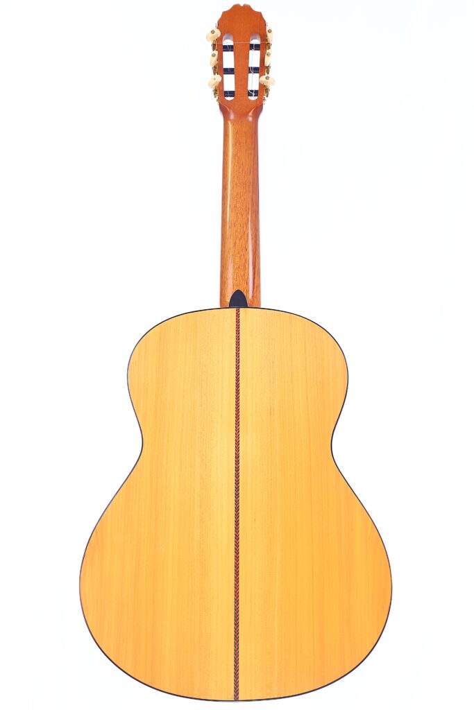 Die Manuel Reyes Model 2021 Von Hippner Flamenco Gitarre Wird Von Hinten Gezeigt Und Präsentiert Ihren Holzkörper, Die Mittelfuge Und Die Kopfplatte Mit Stimmwirbeln Vor Einem Weißen Hintergrund.