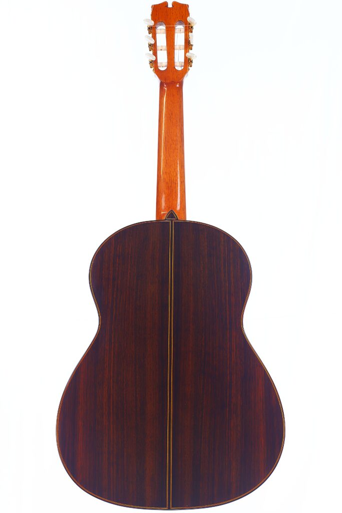 Das Bild Zeigt Die Rückansicht Einer Luis Sanchez 2011 Negra Flamenco Gitarre Mit Einem Dunklen Holzkörper, Einer Hellen Mittelnaht Und Einem Hellbraunen Hals Und Kopfplatte.