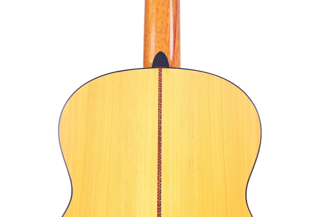 Die Manuel Reyes Model 2021 Von Hippner Flamenco Gitarre Hat Eine Holzrückseite Mit Einer Vertikalen Dekorativen Einlage Und Einem Verlängerten Hals, Der Aus Der Oberseite Herausragt.