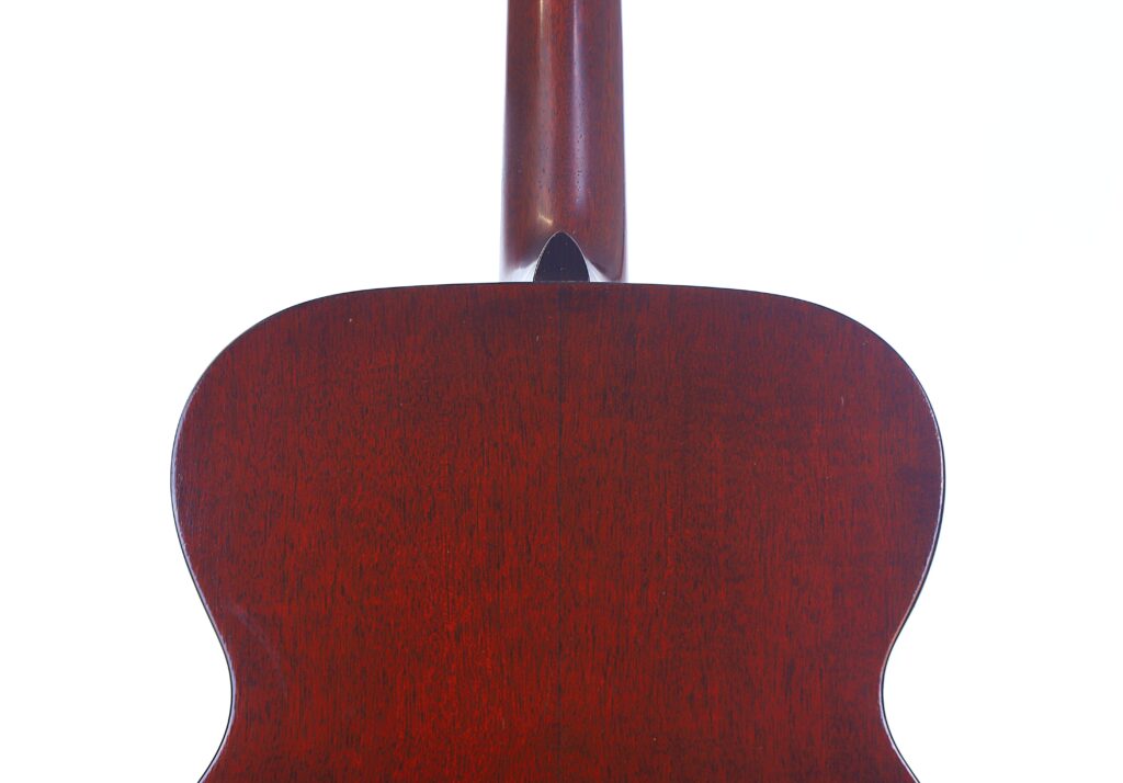 Nahaufnahme Der Rückseite Einer Martin 000-18 1958 Akustik Gitarre, Mit Poliertem Rotbraunem Holz Am Korpus Und Am Unteren Hals, Vor Einem Weißen Hintergrund.