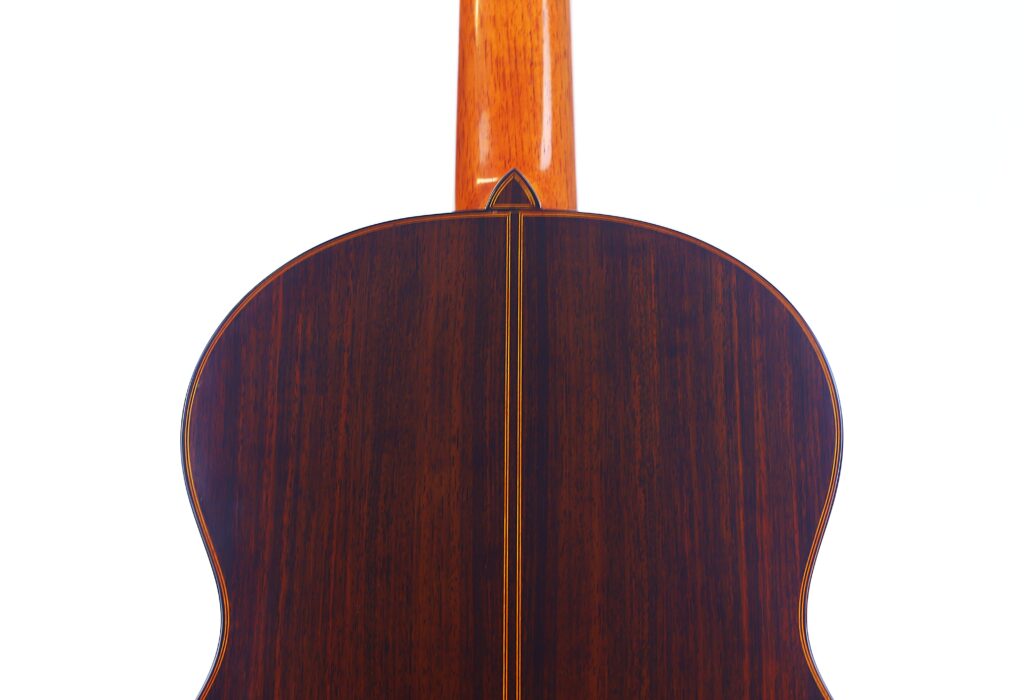 Das Bild Zeigt Die Rückseite Einer Luis Sanchez 2011 Negra Flamenco Gitarre, Die Eine Polierte, Dunkle Holzoberfläche Mit Einer Helleren Mittelnaht Und Einem Glatten, Hellfarbigen Hals Zeigt, Alles Vor Einem Weißen Hintergrund.