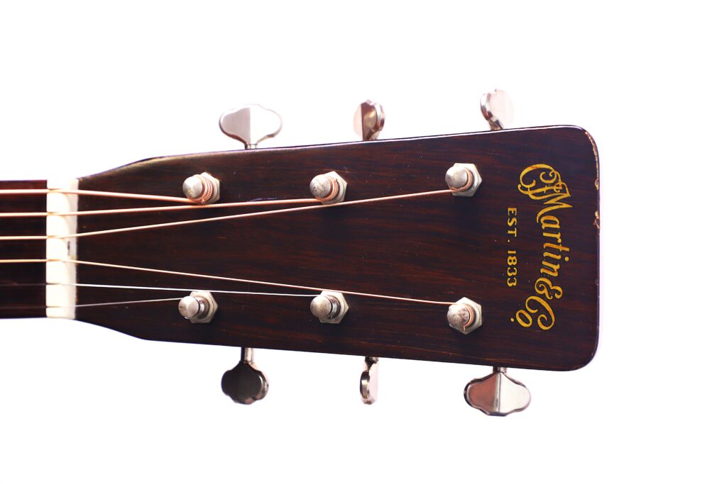 Nahaufnahme Der Kopfplatte Der Martin 000-18 1958 Akustik Gitarre, Mit Sechs Stimmwirbeln Und Dem Martin &Amp; Co. Est. 1833 Logo In Goldener Schrift Auf Dunklem Holz.