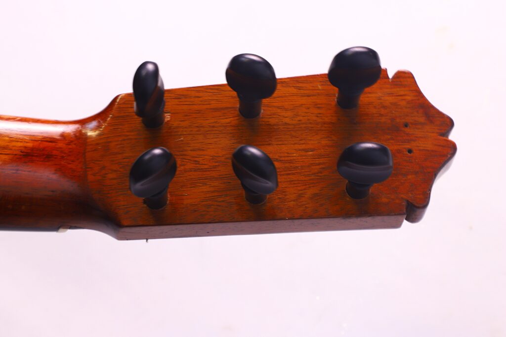 Santos Hernandez 1930 弗拉门戈吉他琴头特写,纯白背景下有六个黑色音栓。.
