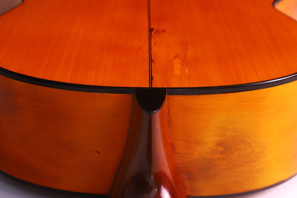 Santos Hernandez 1930 弗拉门戈吉他琴背和琴颈连接处特写,突出木纹、温暖的棕橙色调和精湛的工艺。.