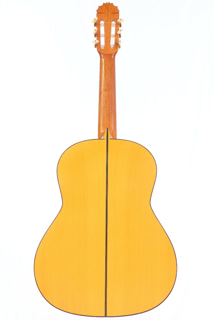 Von Hinten Ist Die Manuel Reyes 1991 Flamenco Guitar Zu Sehen, Mit Hellem Holzkorpus Und Dunkler Mittelnaht, Holzhals Und Goldenen Stimmwirbeln Vor Weißem Hintergrund.