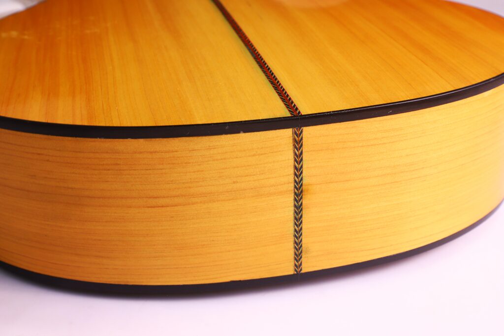 Nahaufnahme Der Manuel Reyes Model 2021 Von Hippner Flamenco Gitarre, Die Ihr Helles Holzfinish, Die Dekorative Nahteinlage Und Die Glatte, Glänzende Rück- Und Seite Hervorhebt.