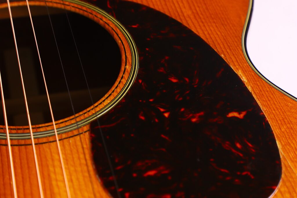 Nahaufnahme Des Schalllochs, Der Saiten Und Des Schildpatt-Gemusterten Schlagbretts Einer Martin 000-18 1958 Akustik Gitarre Auf Ihrem Holzkorpus.