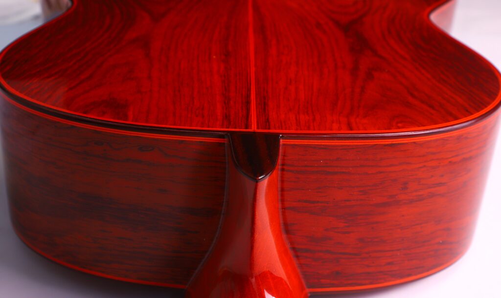 Nahaufnahme Der Glänzenden, Rötlich-Braunen Hölzernen Rückseite Und Der Seiten Der Hermanos Conde 1991 Paco De Lucia Special Flamenco Gitarre, Die Ihre Exquisite Holzmaserung Und Ihre Meisterhafte Handwerkskunst Zeigt.